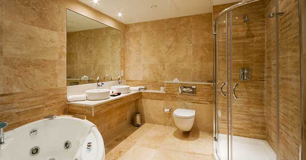 Modern bathroom featuring a glass shower enclosure, dual sinks, and a whirlpool tub, highlighting The Plumbing Dr.'s shower installation services in Arlington.